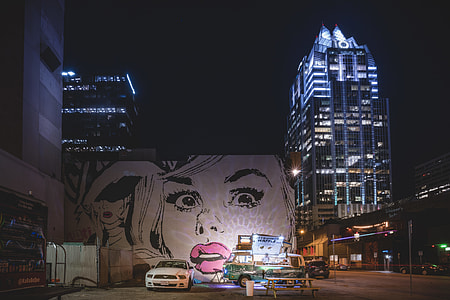 white Ford Mustang near grafiti painting of woman at night thumbnail