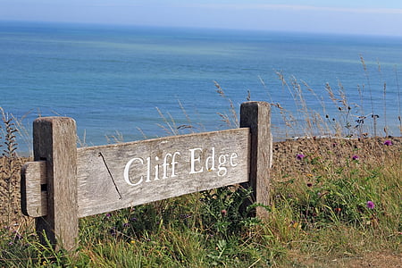 brown wooden signage near body of water thumbnail