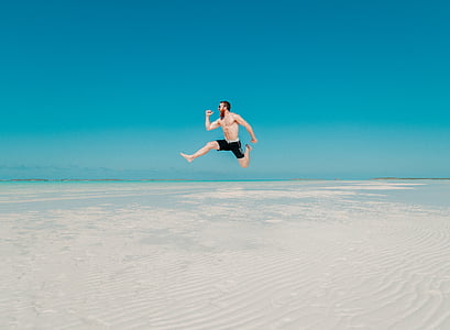 man wearing black jumping over white sand thumbnail