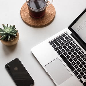 MacBook Pro with gray iPhone X on table thumbnail