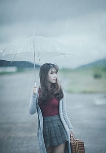 woman wearing gray cardigan holding white handle umbrella thumbnail