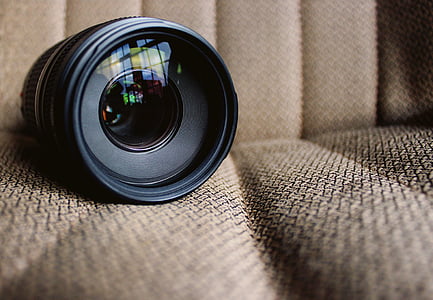 black DSLR camera lens on beige seat thumbnail