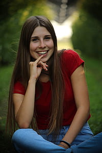 woman sitting on grass covered ground thumbnail