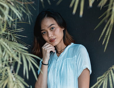 woman putting her hand on chin while standing thumbnail