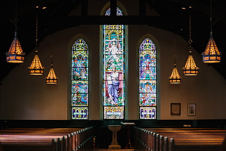interior of church with pews and stained glass window thumbnail