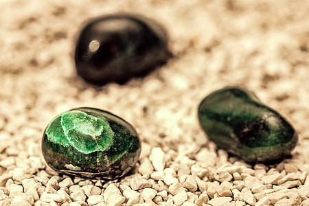three green and black stones on white surface thumbnail