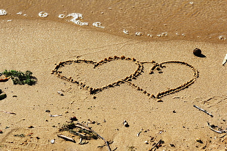 two heart-shaped on gray sand during daytime thumbnail