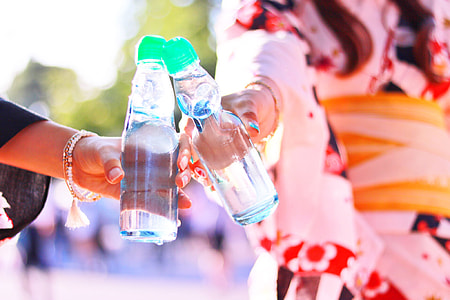 two people holding clear plastic bottles thumbnail