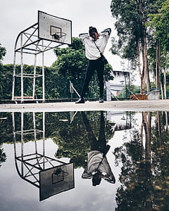 woman raising hear arms standing near basketball hoop thumbnail