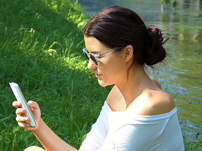 woman using smartphone near river thumbnail