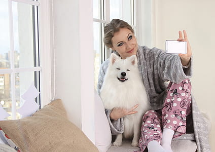 Woman Taking a Photo of Herself With White Dog thumbnail