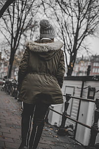 woman with gray parka coat walking on side walk thumbnail