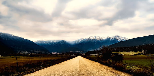 brown road under white clouds thumbnail