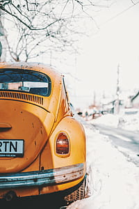 orange Volkswagen Beetle coupe on snow field thumbnail