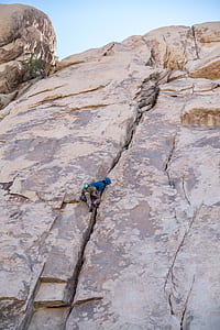 person climbing on cliff during daytime thumbnail