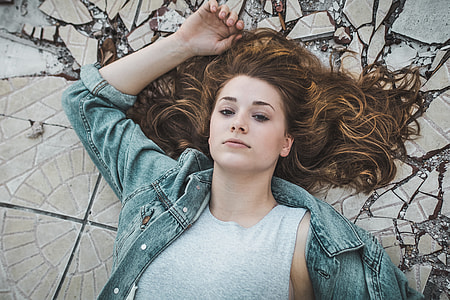 woman wearing blue denim jacket lying on ceramic tile flooring thumbnail