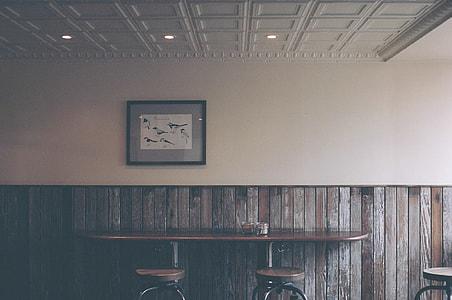 brown wooden table with two chairs beside the wall located inside the room thumbnail