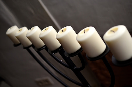 six white candles on black steel holder thumbnail