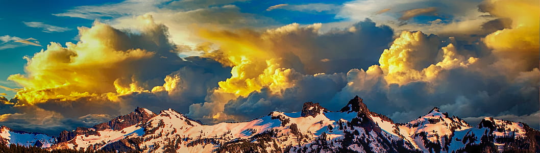 snowy mountain range and yellow clouds at daytime thumbnail