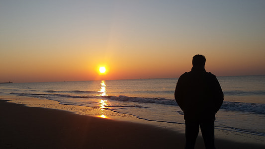 silhouette of person standing on beach thumbnail