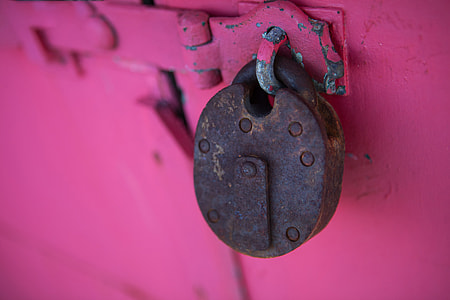 Close-up shot of a rusty lock captured against a vivid pink background thumbnail