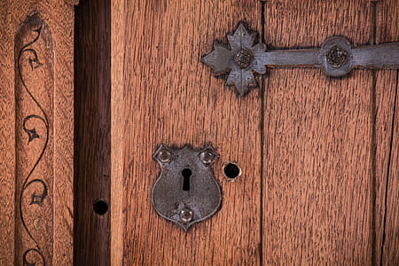 black steel keyhole on brown wooden door thumbnail