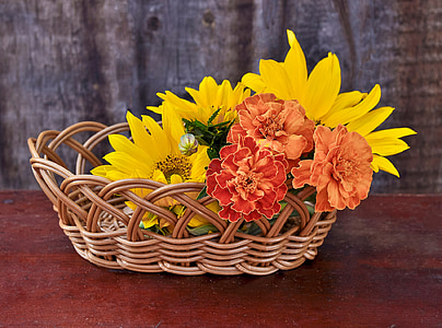 sunflowers and red petaled flowers in brown wicker basket thumbnail