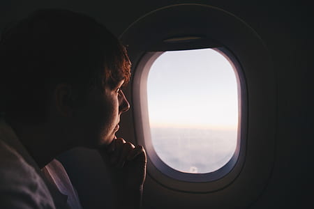 man sitting inside airline watching sky thumbnail
