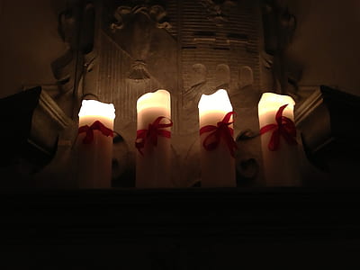 four lighted white pillar candles thumbnail