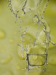 clear rocks glass with clear beverage spilling out thumbnail