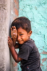 boy leaning on gray concrete wall thumbnail