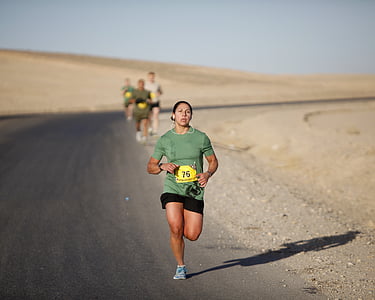 selective focus photography of running woman wearing green shirt on road during daytime thumbnail