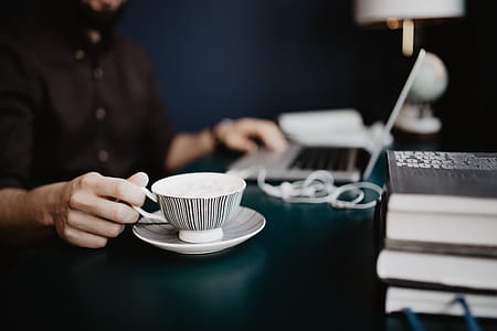 Male working with a laptop and a cup of coffee thumbnail