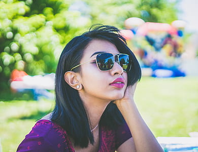selective focus photo of woman sitting near green grass field during daytime thumbnail