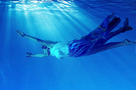 swimming woman wearing white and blue dress in water thumbnail