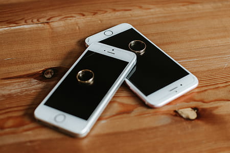 Two Rose Gold Iphone 6s on Brown Wooden Surface thumbnail