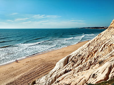 people walking towards ocean during daytime thumbnail