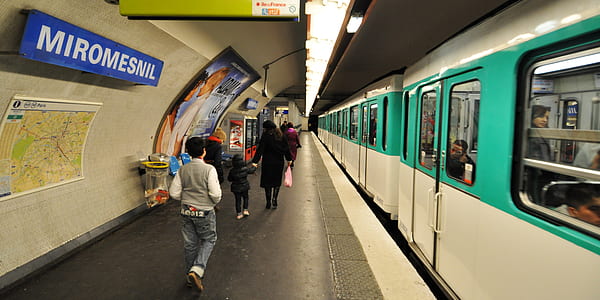 people walking beside train station thumbnail