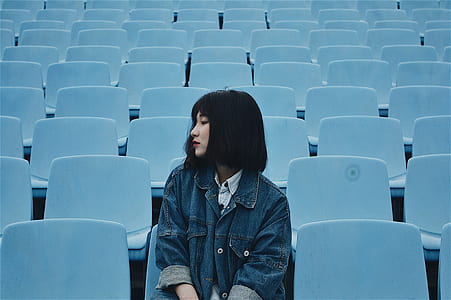 woman wearing blue jacket sitting on gang chair thumbnail