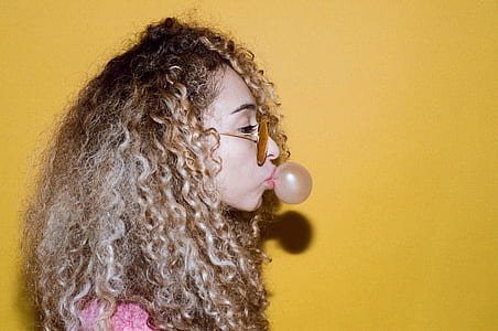 woman blowing chewing gum into ball against wall thumbnail