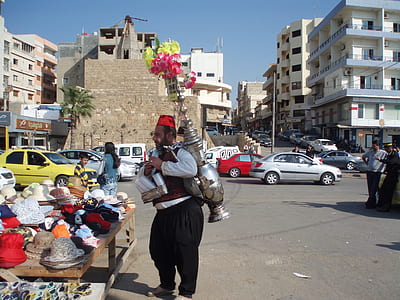 man carrying flowers in vase on street during daytime thumbnail