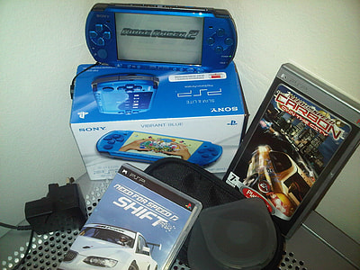 blue Sony PSP beside two game acses thumbnail