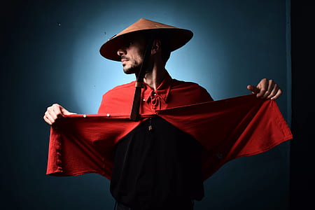 man lifting his red shirt wearing brown hat thumbnail