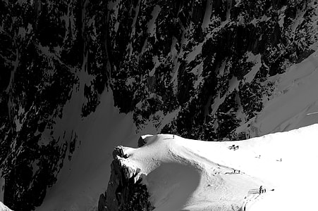 aerial view photography of people standing on mountain cliff covered by snow during daytime thumbnail