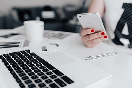 Businesswoman uses her mobile phone at her desk thumbnail