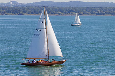 brown and white sailboat on calm body of water during daytime thumbnail