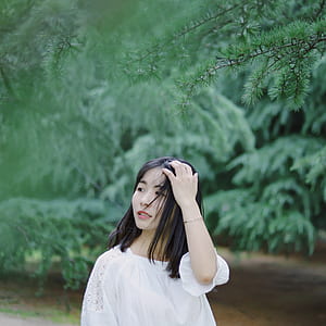 woman wearing white 3/4-sleeved top in front trees thumbnail