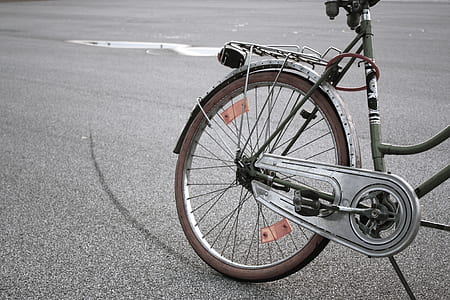gray bicycle parked on black asphalt road thumbnail