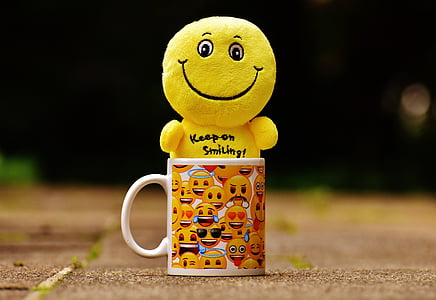 yellow emoji toy in yellow ceramic mug thumbnail