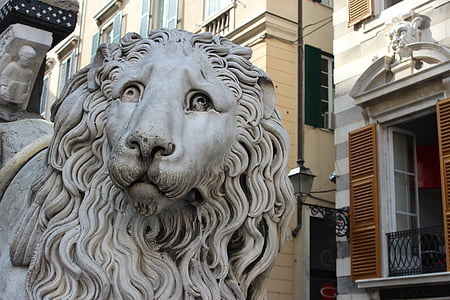 gray lion statuette near brown building thumbnail